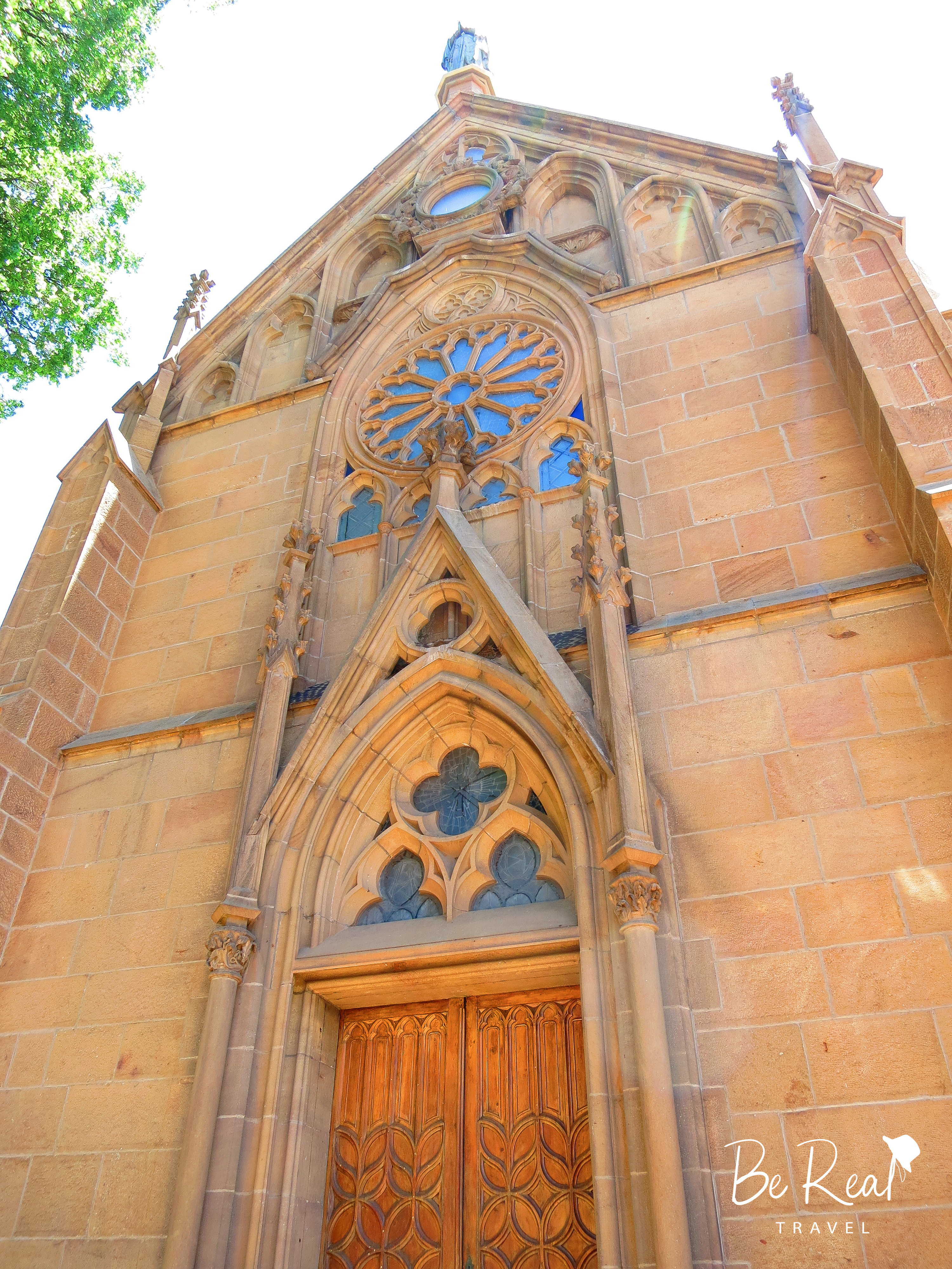 A church with intricately-designed windows towers over the viewer in Santa Fe, New Mexico