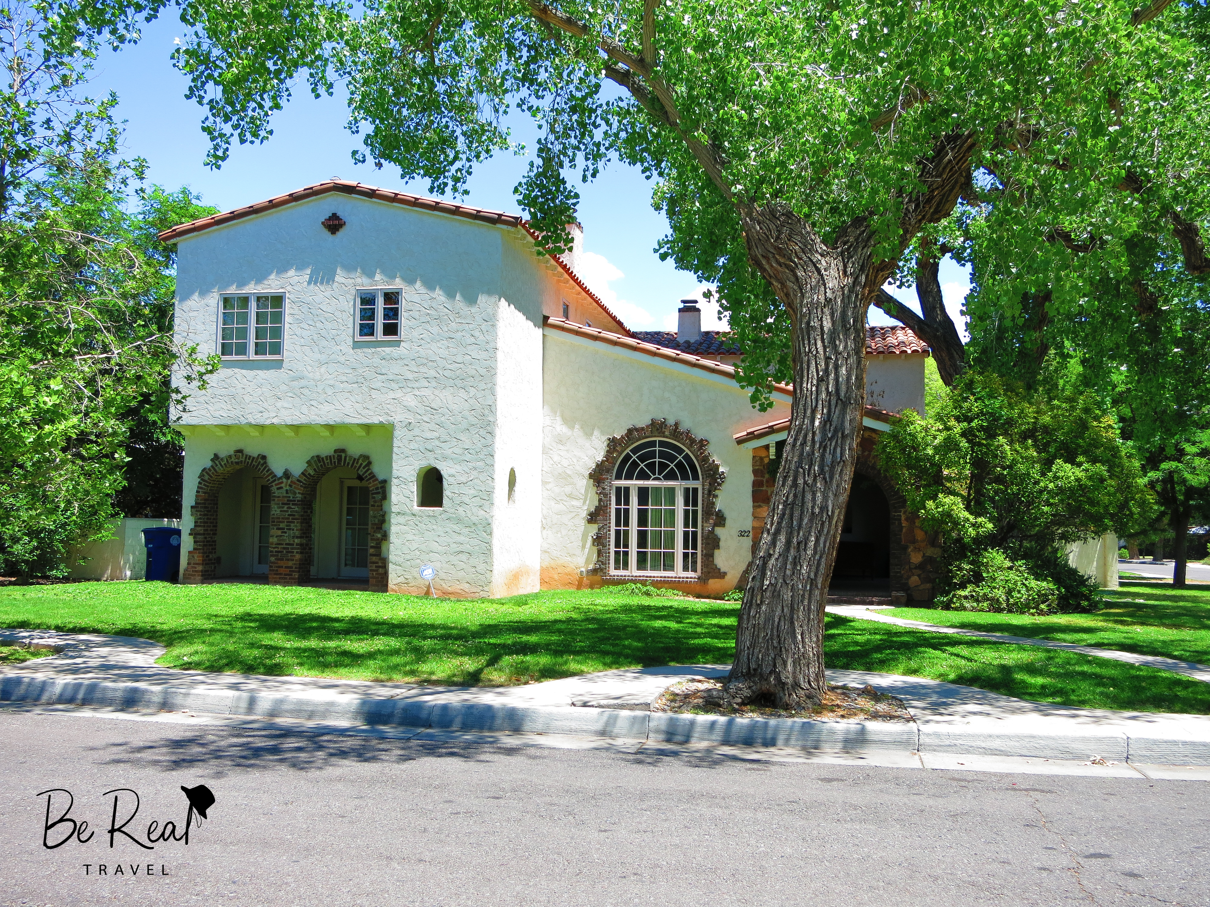 A two-story white house sits behind a large tree; this house was Jesse Pinkman's house in New Mexico Breaking Bad