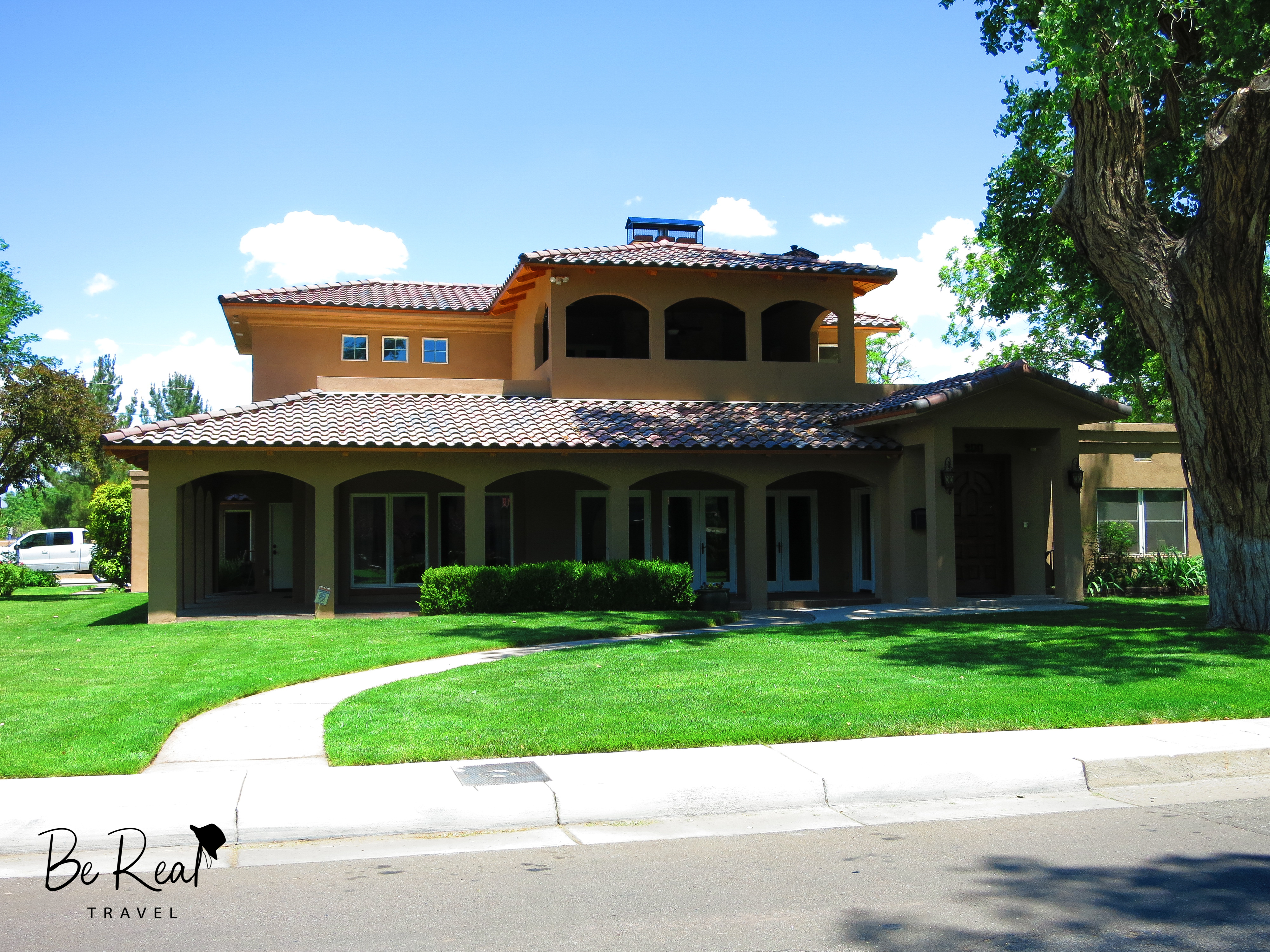 A two-story house with large windows sits behind a verdant lawn; this house was Ted Beneke's house in New Mexico Breaking Bad
