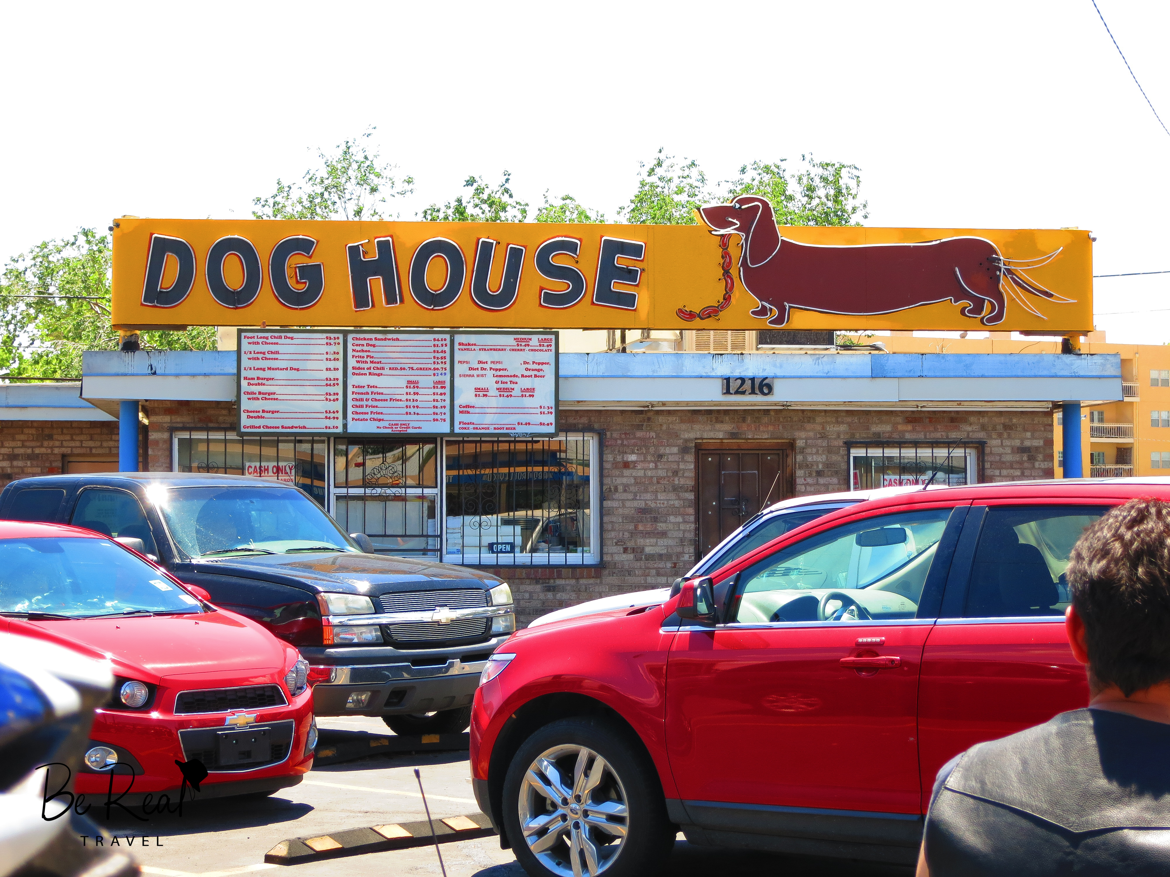 An lengthy dog holds mini hot digs in its mouth on a sign for the Dog House eatery; Jesse Pinkman bought a gun here in New Mexico Breaking Bad